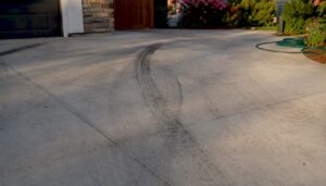 Close-up of tire marks on concrete driveway