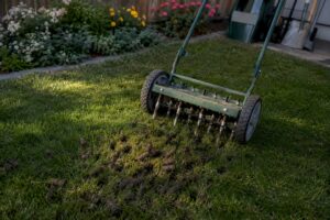 Deep core aeration machine penetrating compacted lawn