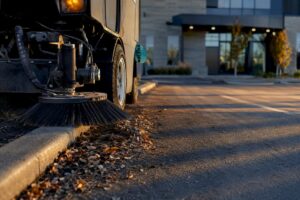 Parking lot sweeper clearing curbside debris