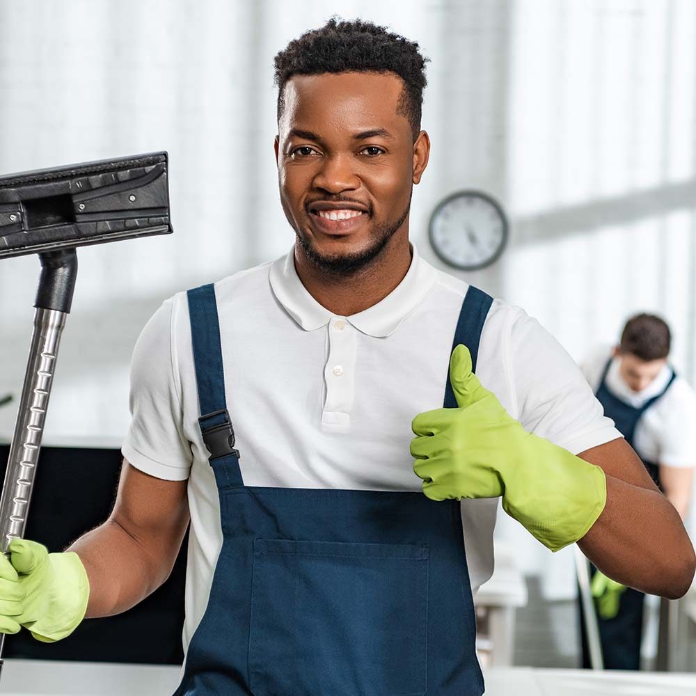 smiling-african-american-cleaner-holding-vacuum-cl3-Z9YUQND.jpg